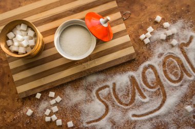 Masadaki yazı şekeri, şeker kasesindeki rafine şeker..