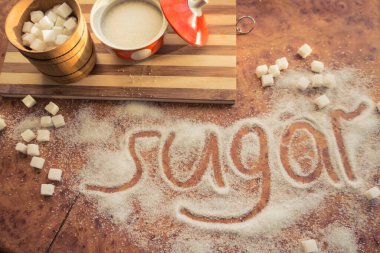 Masadaki yazı şekeri, şeker kasesindeki rafine şeker..