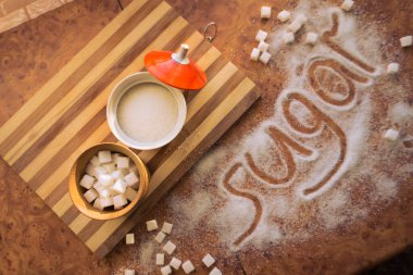 Masadaki yazı şekeri, şeker kasesindeki rafine şeker..