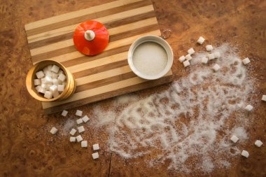 Şeker ve rafine şeker masanın üstüne saçılmış..