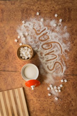 Masadaki yazı şekeri, şeker kasesindeki rafine şeker..