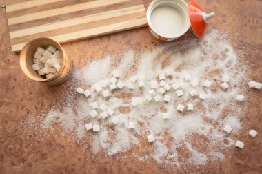 Şeker ve rafine şeker masanın üstüne saçılmış..