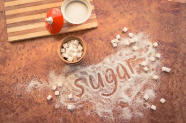 Masadaki yazı şekeri, şeker kasesindeki rafine şeker..