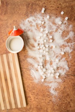 Şeker ve rafine şeker masanın üstüne saçılmış..