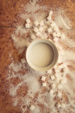 Şeker ve rafine şeker masanın üstüne saçılmış..