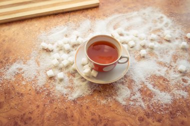 Şeker ve rafine şeker masanın üstüne saçılmış..