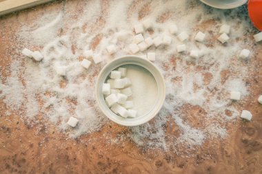 Şeker ve rafine şeker masanın üstüne saçılmış..