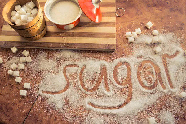 Masadaki yazı şekeri, şeker kasesindeki rafine şeker..