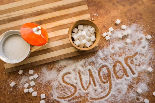 Masadaki yazı şekeri, şeker kasesindeki rafine şeker..