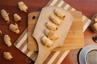 Elma reçelli kruvasan ve ahşap arka planda bir fincan kahve..