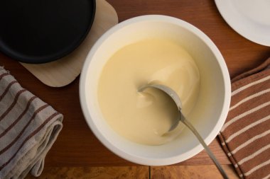 Krep haftası. Yumurta, un, tereyağı ve süt karışımından lezzetli ve kanlı krepler pişirmek için hamur hazırlığı. Maslenitsa geleneksel Rus festivali yemeği.