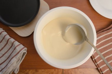 Krep haftası. Yumurta, un, tereyağı ve süt karışımından lezzetli ve kanlı krepler pişirmek için hamur hazırlığı. Maslenitsa geleneksel Rus festivali yemeği.