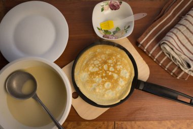 Krep haftası. Yumurta, un, tereyağı ve süt karışımından lezzetli ve kanlı krepler pişirmek için hamur hazırlığı. Maslenitsa geleneksel Rus festivali yemeği.