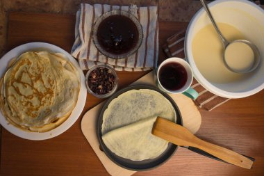 Krep haftası. Yumurta, un, tereyağı ve süt karışımından lezzetli ve kanlı krepler pişirmek için hamur hazırlığı. Maslenitsa geleneksel Rus festivali yemeği.