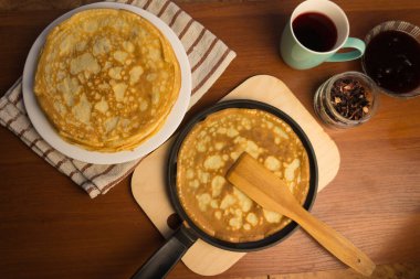 Krep haftası. Yumurta, un, tereyağı ve süt karışımından lezzetli ve kanlı krepler pişirmek için hamur hazırlığı. Maslenitsa geleneksel Rus festivali yemeği.