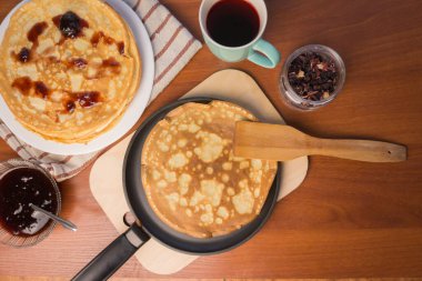 Krep haftası. Yumurta, un, tereyağı ve süt karışımından lezzetli ve kanlı krepler pişirmek için hamur hazırlığı. Maslenitsa geleneksel Rus festivali yemeği.