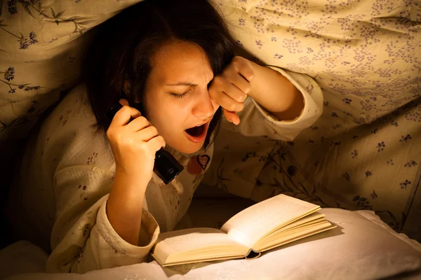 Bocejando mulher lendo um livro — Fotografia de Stock