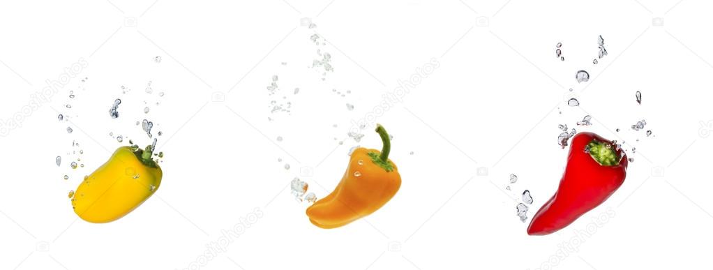 Yellow, orange and red capsicum in water with air bubbles