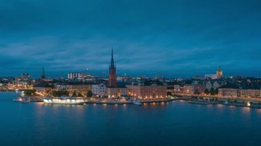 İsveç 'in başkenti Stockholm' de gün batımında gökyüzü ve aydınlık şehirle birlikte gökyüzünde hareket eden bulutlar
