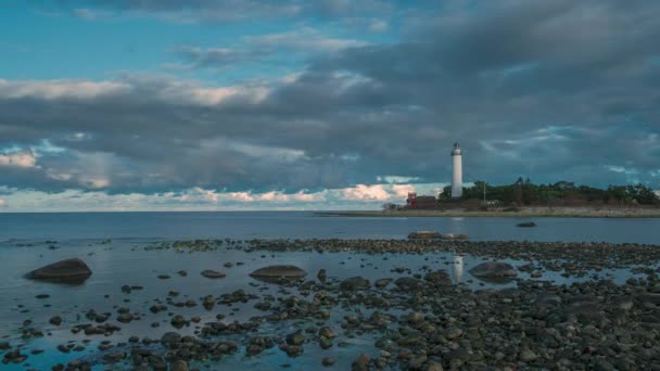 劇的な移動雲 正面の石の海岸と日没の間にオーランド北部の島のスウェーデン灯台ランゲエリックの時間経過 — ストック動画