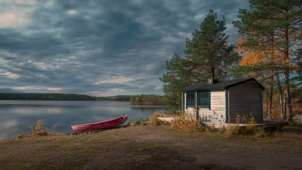 在瑞典北部Jokkmokk附近的Stor Skabram湖的两艘船和小棚屋的时间流逝 阳光和云彩在天空中飘扬 — 图库视频影像