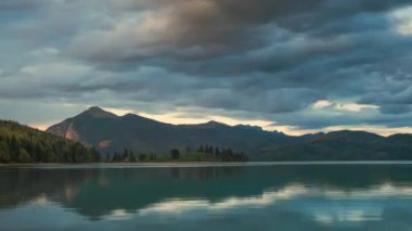 Gün batımında hareket eden bulutlar ve dağlarla Walchensee Gölü 'nün zaman kayması, suda yansıma, Bavyera