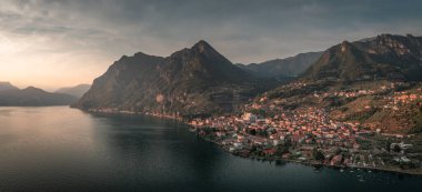 Iseo Gölü 'ndeki dağ manzarası dağlarla ve Marone köyüyle günbatımında, İtalya' da.