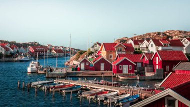 Harbor and coast in the village of Kyrkesund on the archipelago island of Tjoern on the west coast of Sweden, blue sky with sun