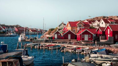 Harbor and coast in the village of Kyrkesund on the archipelago island of Tjoern on the west coast of Sweden, blue sky with sun