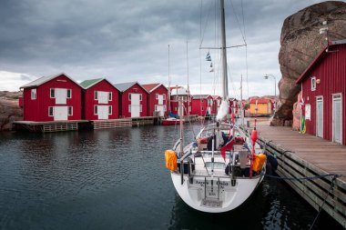 Bay with red boathouses and boat in Smoegen on the west coast of Sweden