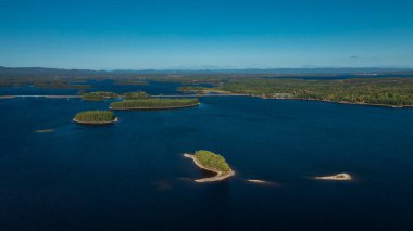 Dalarna, İsveç 'te Siljan Gölü' ndeki adaları yukarıdan mavi gökyüzü ile Lakeshore.