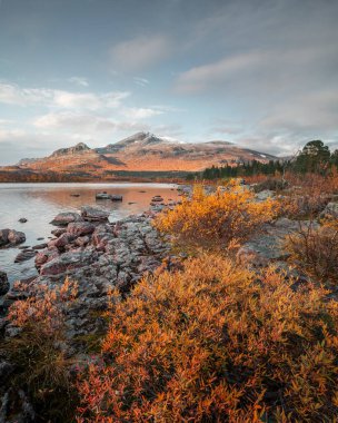 Mountain landscape with lake and rocks in Stora Sjoefallet National Park in autumn in Lapland in Sweden from above during sunset