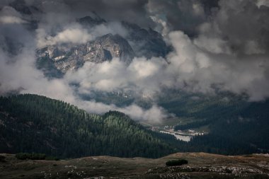 Dolomite Alpleri 'nde dağların önünde oteli olan Misurina Gölü gökyüzünde bulutlar olan Güney Tyrol İtalya