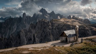 Chapel Cappella degli Alpini Dolomite Alplerinde Dağ Panoraması 'nın önünde İtalya' nın Üç Tepesi 'nde, bulutlar gökyüzünde