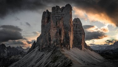 Güney Tyrol 'daki Dolomite Alpleri' nde gün batımında bulutlu üç tepe zirvesi.