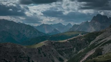 Rifugio Auronzo dağ kulübesinde gündüz vakti Dolomite Alpleri 'nin önünde İtalya' nın Üç Tepesi 'nde, bulutlar gökyüzünde