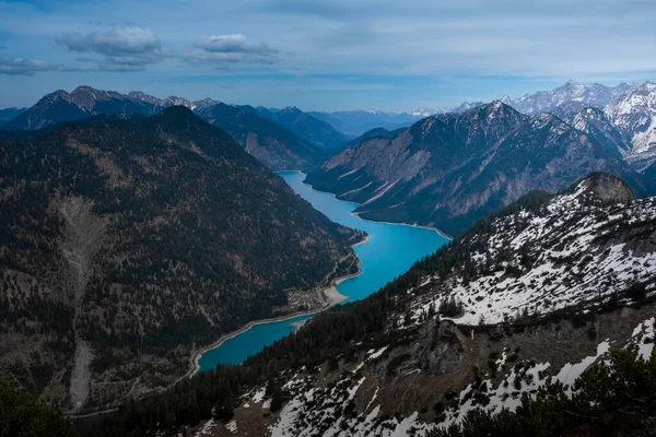 Turquoise colored Lake Plansee with mountains in Tyrol Austria during sunny blue sky weather from above