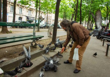 Paris Clishi Bulvarı 'nda güvercin besleyen bir adam (Moulen Rouge restoranının yanında - Paris