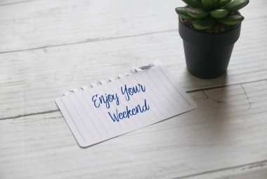 Bitki ve kağıdın seçmeli odak noktası beyaz tahta sırtlı hafta sonunuzun tadını çıkarın.