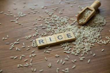 Wooden alphabet and rice on wooden background.