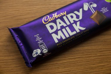 KEDAH, MALAYSIA - 6 Mart 2021: Ahşap arka planda Cadbury Süt Çikolatası. Cadbury Dairy Milk, Cadbury tarafından üretilen bir süt çikolatasıdır..