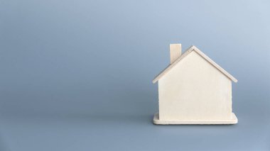 Gri arka planda, kopyalama alanı olan küçük ahşap ev.