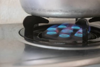 Mutfak sobasından mavi bir ateş. Propan gazı alevleriyle birlikte gaz ocağı..