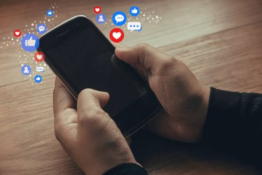 Sosyal medya ikonuyla el ele tutuşan akıllı telefon. Sosyal medya ve dijital internet kavramı.