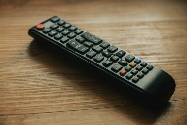 Television remote control isolated on a wooden background.