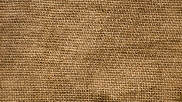 A rough brown burlap cloth background or sack cloth.