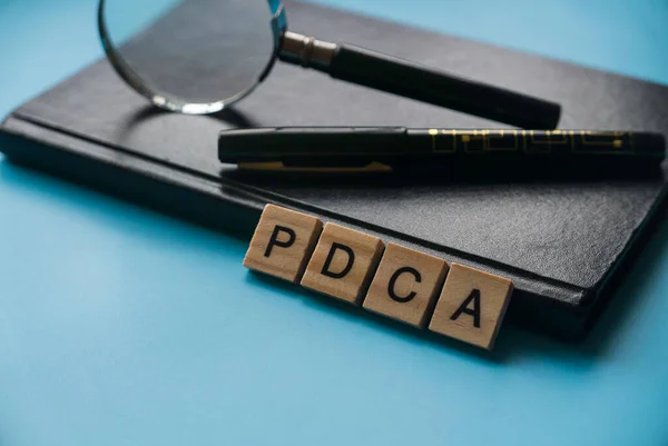 Pdca Plan Check Act Concept Notebook Pen Magnifying Glass Blue — Stockfoto