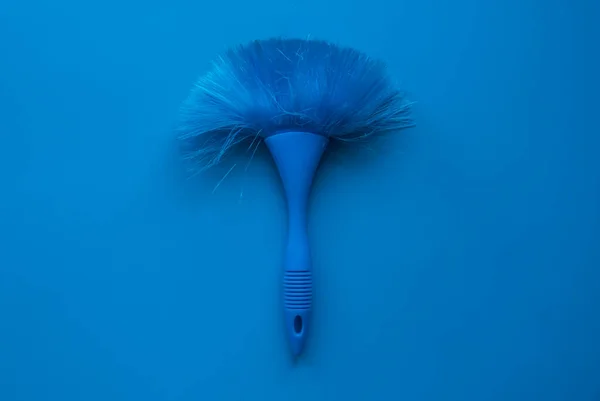 Blue cleaning brush on a blue background.