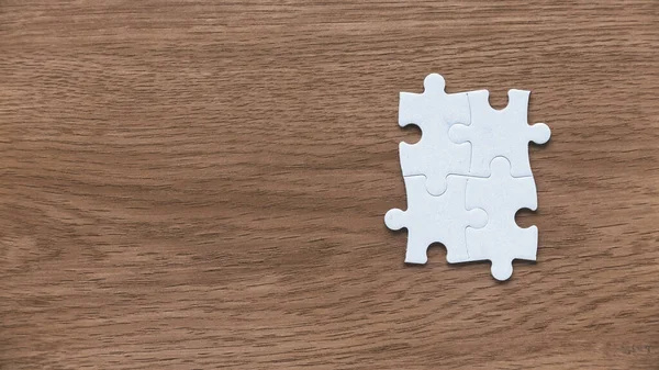 A group of jigsaw puzzle on a wooden background with copy space.