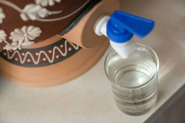 A glass of water from traditional water dispenser called Labu Sayong (water calabash) in Malay language.